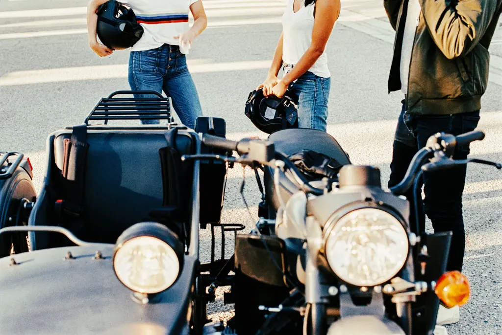 Three unrecognizable young friends taking a break from riding a vintage sidecar. Shot on Fuji film stock, natural film grain, no added grain.